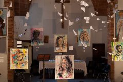 Exibition set during the gold swallow ceremony in 2016. The church was set up with Nadia's painting. Over them paper airplanes simbolizing Rondine's mission.